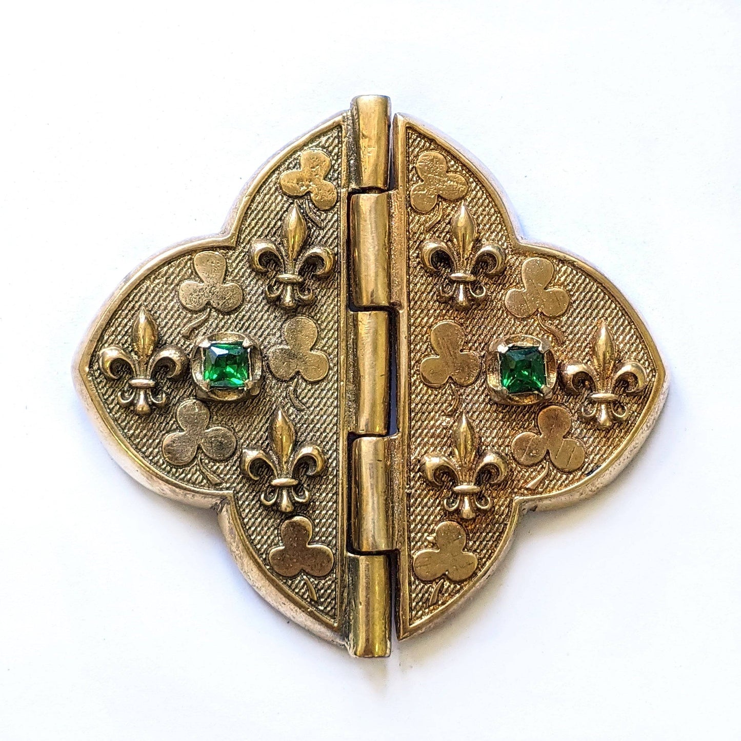 Replica of 14th Century French Cloak Clasp with green CZ gemstones and gold fleur-de-lis, used in medieval costume crafting.