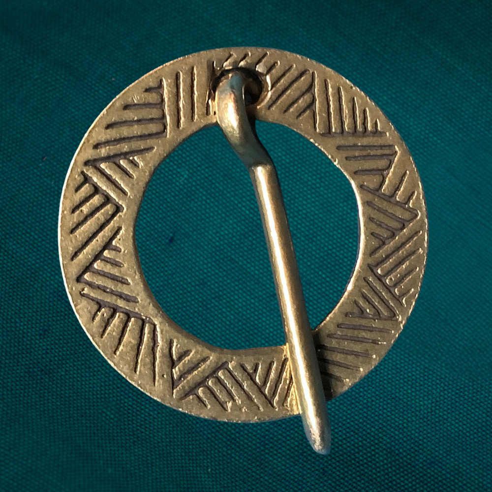 Round Medieval brooch with incised decoration