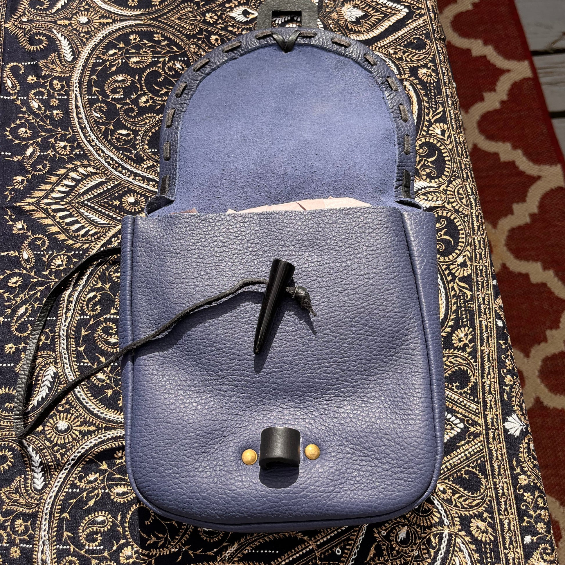 Blue leather bags on a patterned fabric surface