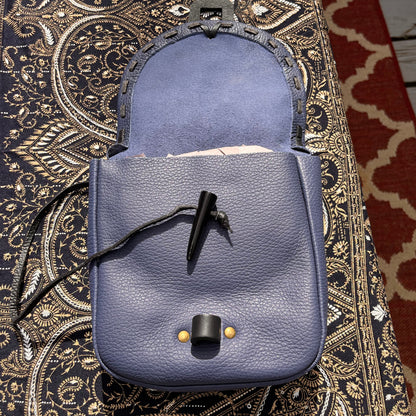 Blue leather bags on a patterned fabric surface