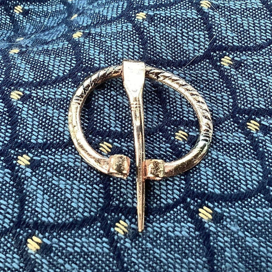 Petite broche médiévale penannulaire en laiton et cuivre
