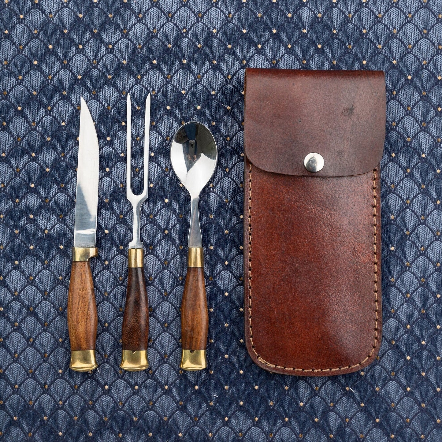 Wood cutlery set with brown leather case that attaches to belt.